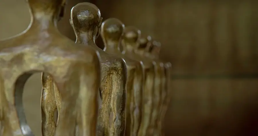 Conjunto de siete figuras escultóricas de Alexandra Saldarriaga alineadas en perspectiva.